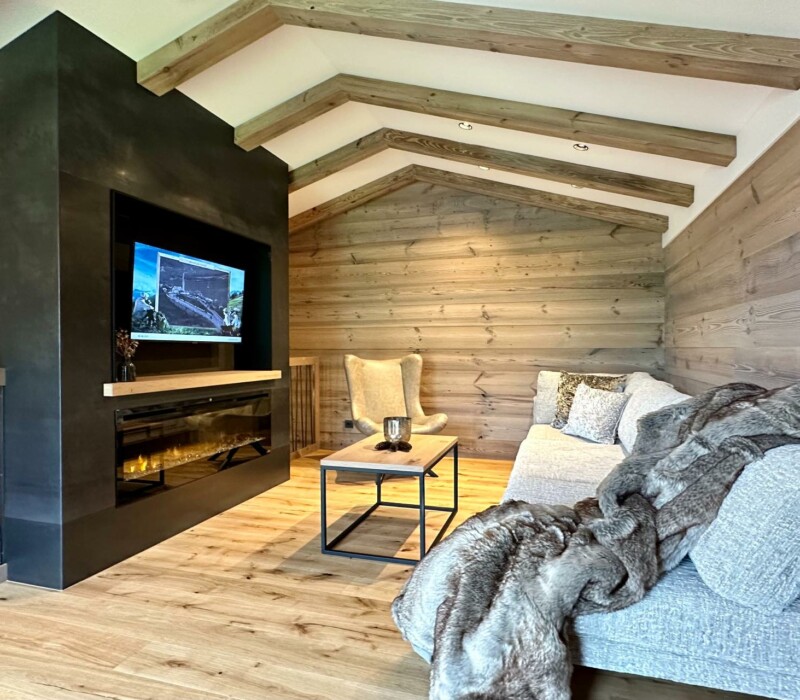 Alpen-Chalet mitten in den Bergen - Traumhafte Lage auf 1.500 m Höhe - Chalets für 6 - 9 Personen - Wohnbereich mit Kamin und TV und gemütlichem Relaxbereich